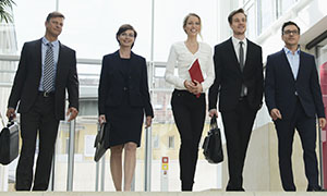Business men and women walking in an office lobby